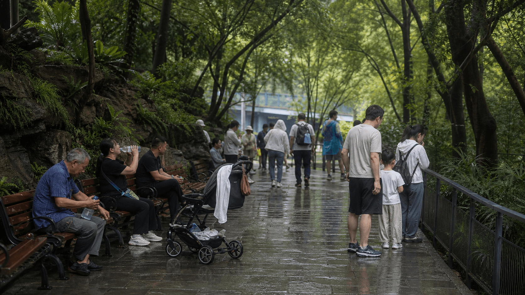 Gia đình nghỉ trên đường cây râm mát và ướt trong Chongqing Zoo