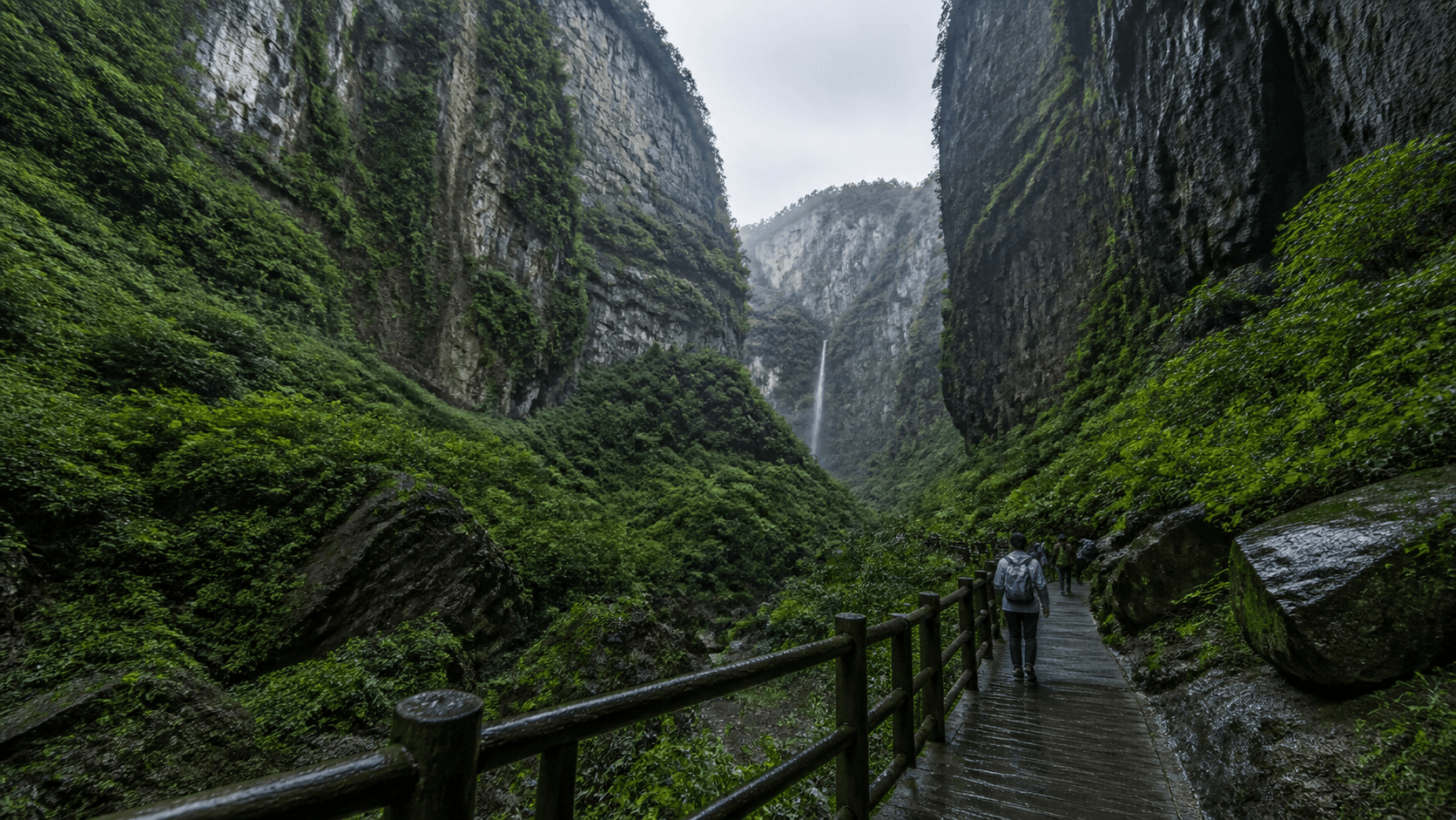 Wet valley-floor boardwalk, handrails and a small waterfall in a Wulong limestone gorge