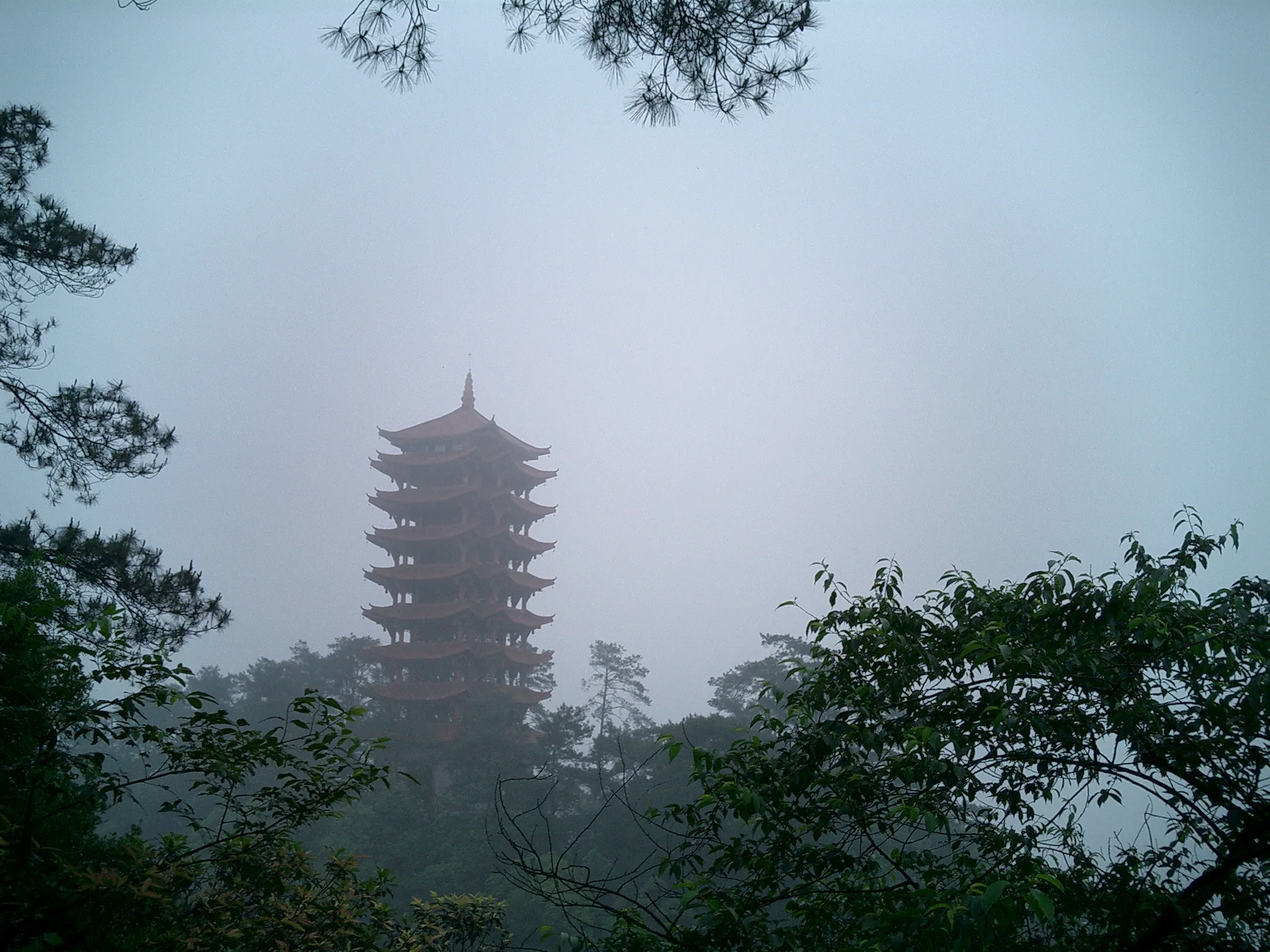 Sebuah pagoda menjulang di antara kabut dan pepohonan di Gunung Jinyun, Chongqing